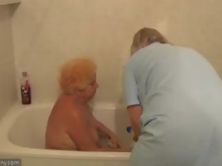 De verpleegster bathes oud vet oma in badkamer